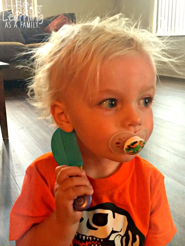 Toddler using comb from Nuby Brush and Comb Set